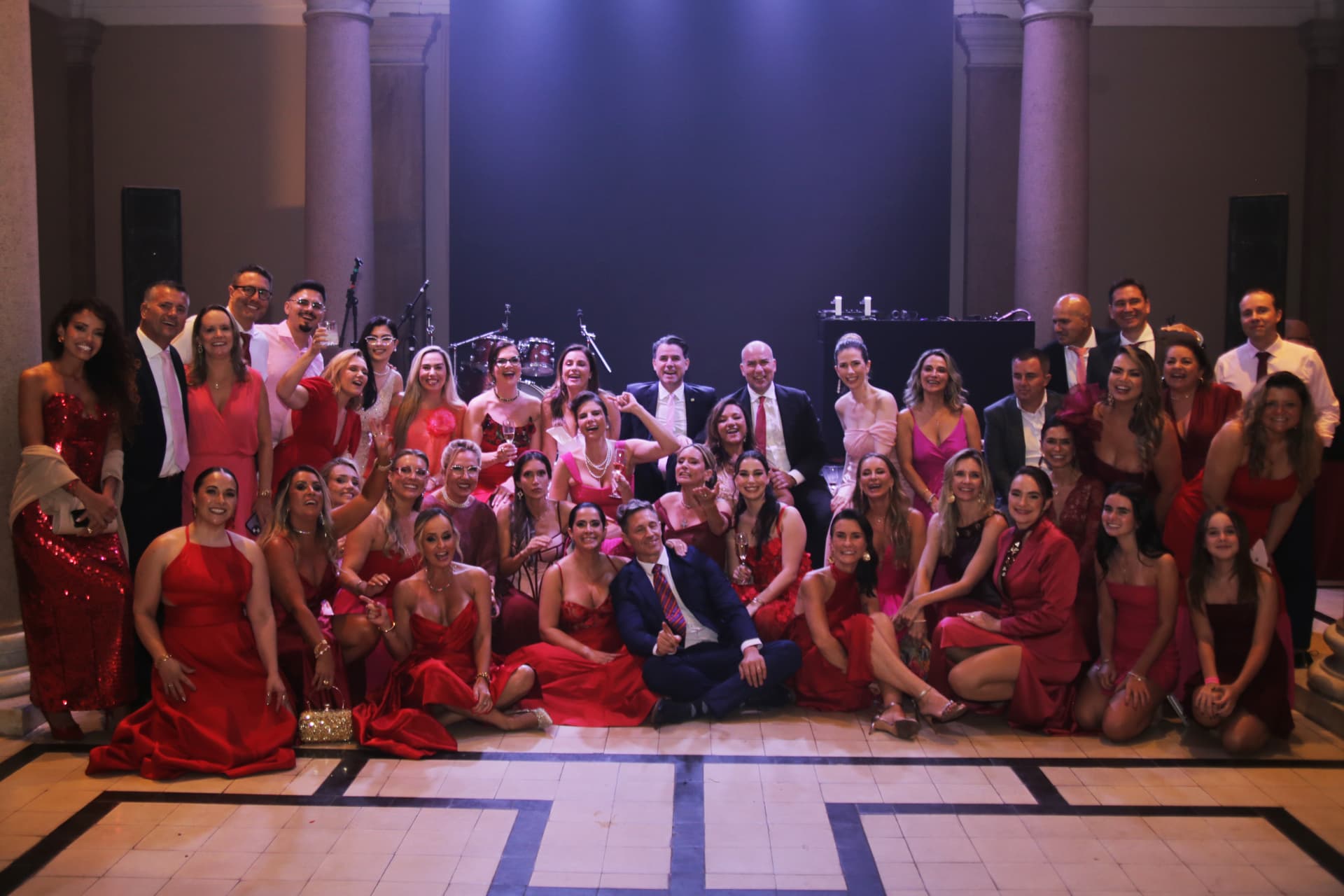Foto coletiva de convidados no palco ao final do Prêmio Aliadas 2026, com instrumentos da banda ao fundo