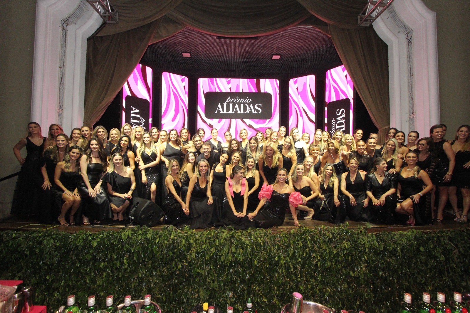 Foto coletiva numerosa de mulheres no palco do Prêmio Aliadas 2024