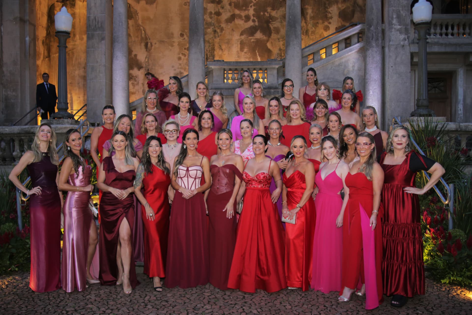 Foto coletiva das participantes do Prêmio Aliadas 2026 nas escadarias da Catedral Metropolitana de Porto Alegre, com vestidos em tons de rosa e vermelho