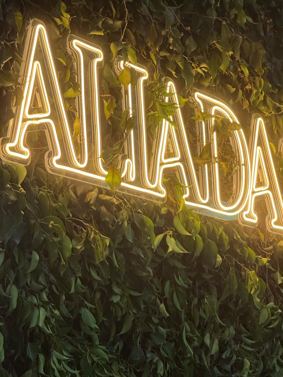 Letreiro luminoso Aliadas em meio a folhagens na decoração do Prêmio Aliadas 2025