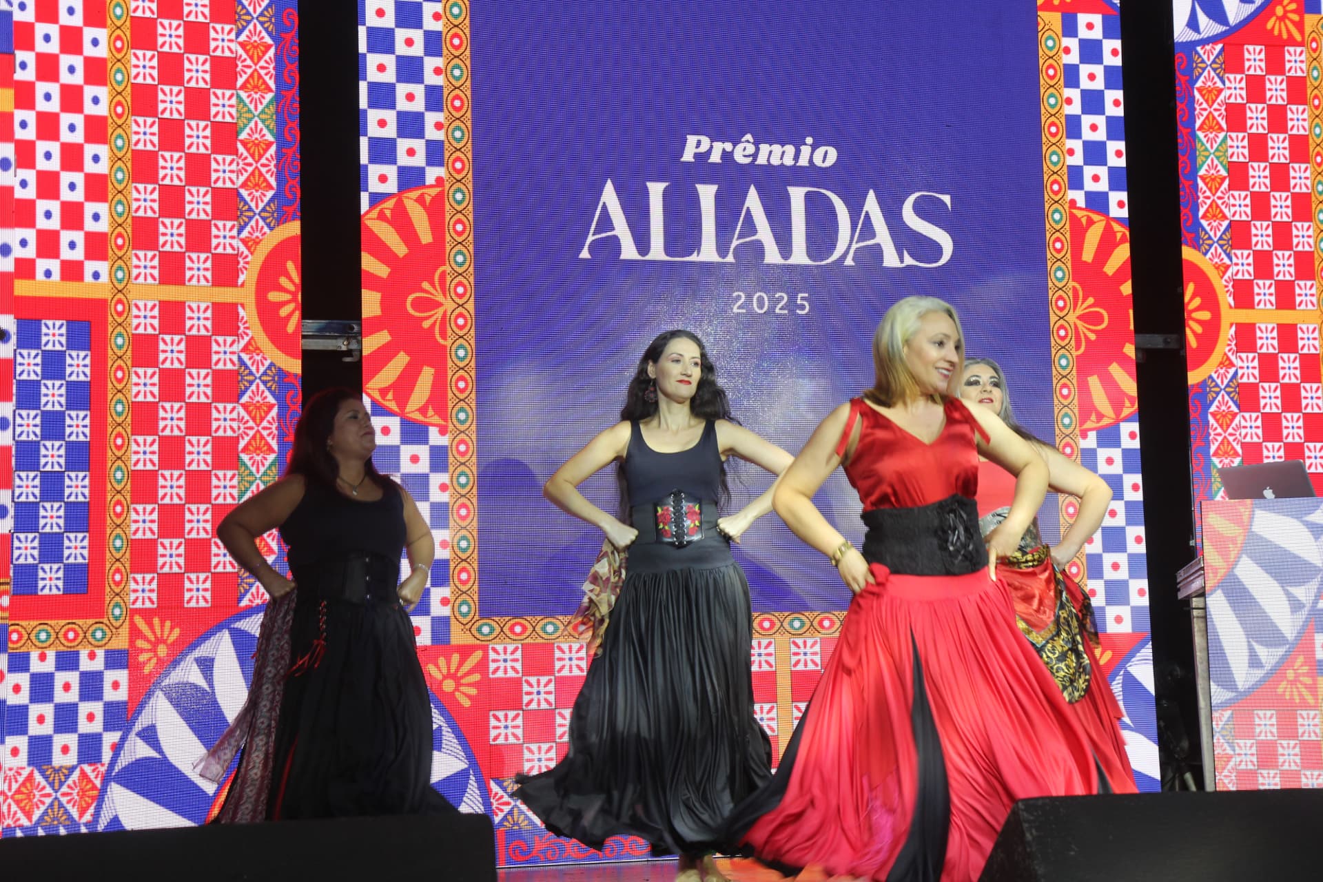 Apresentação de dança no palco do Prêmio Aliadas 2025, com painel exibindo o tema Sicília